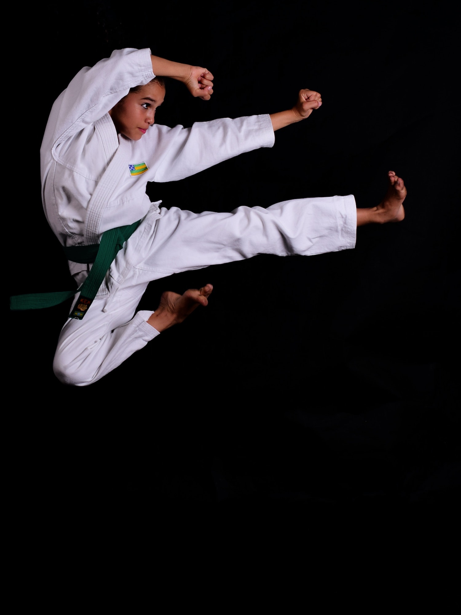 Young boy in martial art outfit jumping in the air